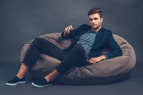 handsome man sitting on beanbag - Fotó, kép