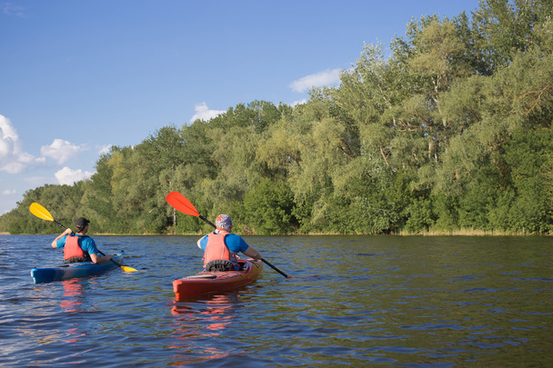 Mens travel by canoe on the river in the summer a sunny day.  - Valokuva, kuva