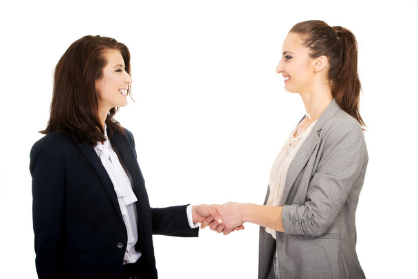 Two women in office outfits giving handshake. - Fotografie, Obrázek