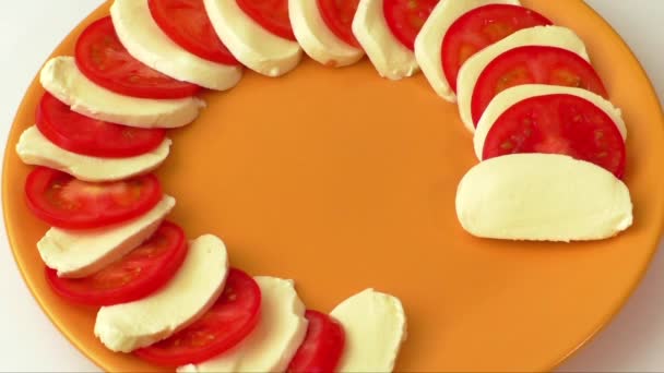 Délicieuse salade au fromage mozzarella et tomates tranchées décorées de basilic
  - Séquence, vidéo