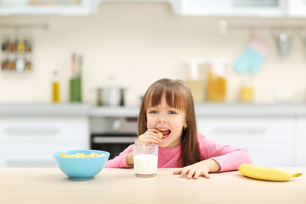 Beautiful little girl having breakfast   - Foto, Bild