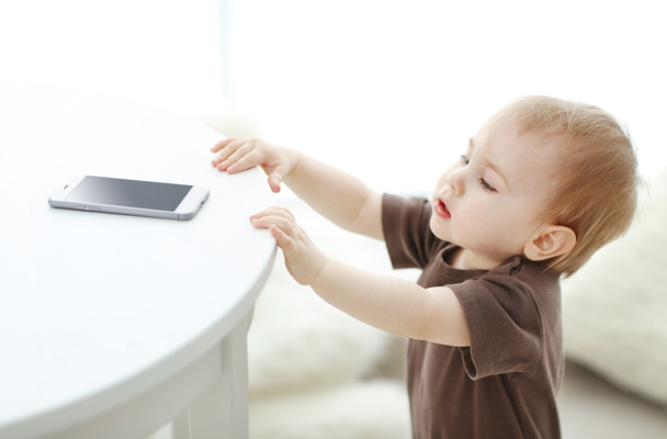 Baby trying to take smartphone - Foto, Bild