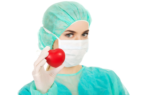 Female surgeon doctor holding heart - Фото, изображение