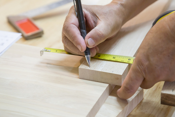 Craftsman measuring wood with ruler - Photo, Image