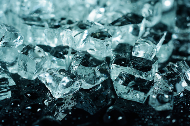 pieces of crushed ice on black background with water drops - Foto, Imagem