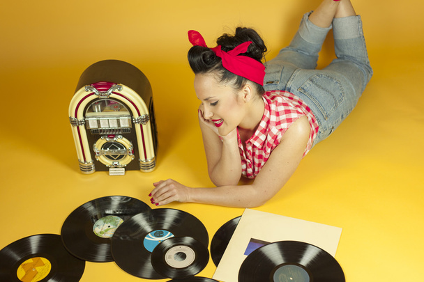 Portrait beautiful pin up listening to music on an old jukebox r - Foto, imagen