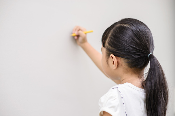 Kid writing on blur grey wall background - Foto, imagen