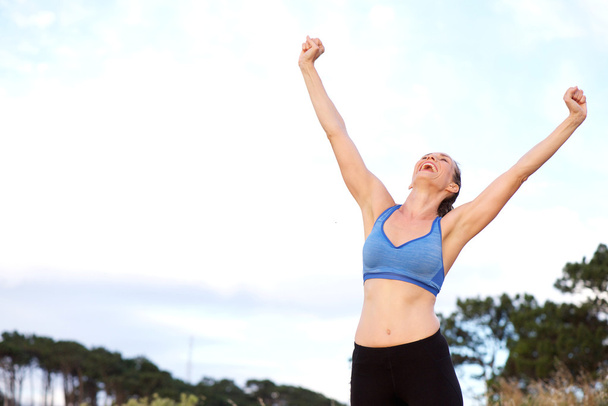Woman cheering with arms raised outdoors - Photo, Image