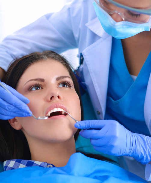 Woman dentist working at her patients teeth - Photo, Image