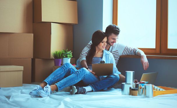 Young couple  sitting on the floor of their new apartment - Foto, Imagem