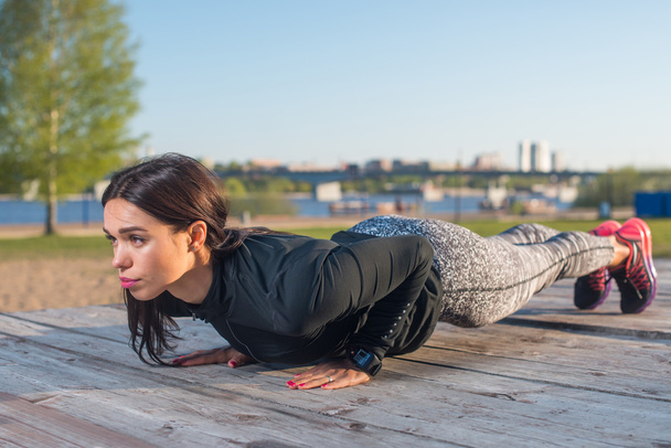 Sportliche junge Frau beim Planken   - Foto, Bild