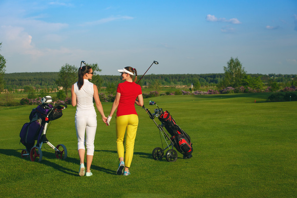İki güzel kadın golfçüler Golf Sahası yürüyüş - Fotoğraf, Görsel