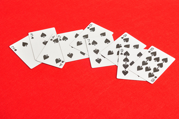 Playing card. Two to ten of spades isolated on a red background - Foto, immagini