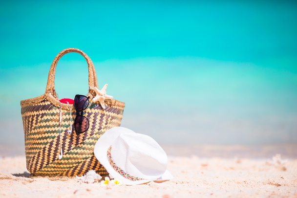 Strand kiegészítők - szalma táska, napszemüveg, kalap, a strandon - Fotó, kép
