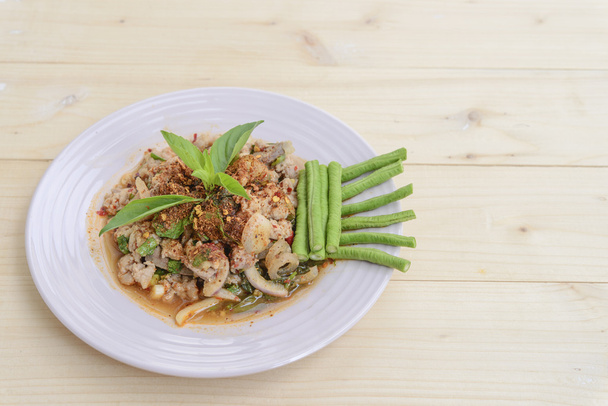 Thai food; Lab-Moo; Chopped pork mix with Thai spicy curry; Thai dry chilli crush topping; wood background  - Zdjęcie, obraz
