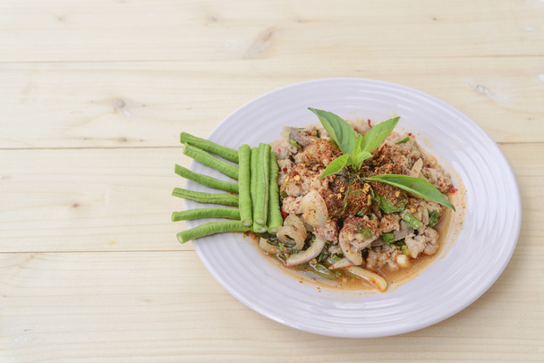 Thai food; Lab-Moo; Chopped pork mix with Thai spicy curry; Thai dry chilli crush topping; wood background  - Zdjęcie, obraz