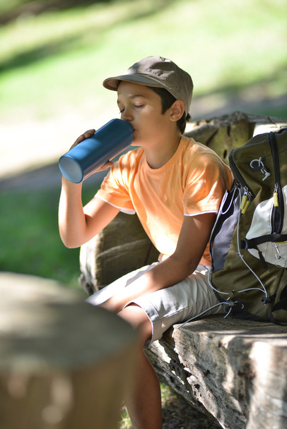 Young boy sitting drinking water - Foto, afbeelding