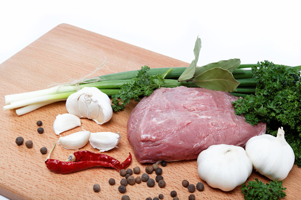 Сырое мясо, овощи и специи изолированы на деревянном столе
. - Фото, изображение