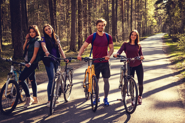 Vier lachende volwassenen met fietsen - Foto, afbeelding