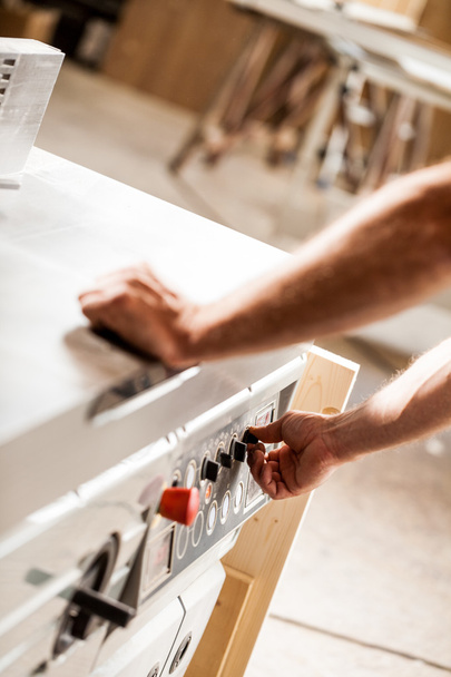 turning on or off a machine in a woodworker workshop - 写真・画像