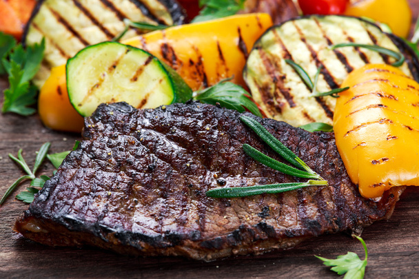 Sığır eti biftek ve ızgara sebze. Karanlık kesme tahtası üzerinde - Fotoğraf, Görsel