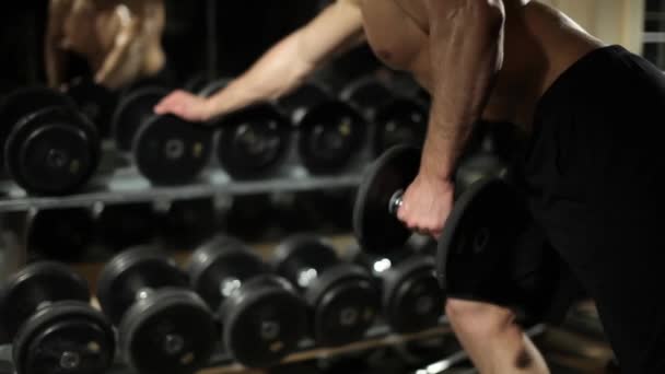 Guy in the gym. Does exercises with dumbbells. - Footage, Video