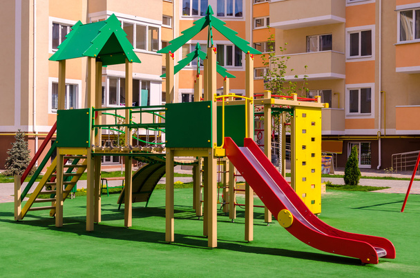 neue bunte Kinderspielanlage im Hof eines Mehrfamilienhauses - Foto, Bild