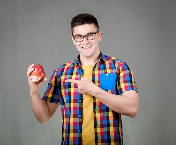 Man with apple isolated on gray background - Foto, Imagen
