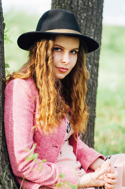 Portrait young elegant woman in pink coat and black hat. Fashion - 写真・画像