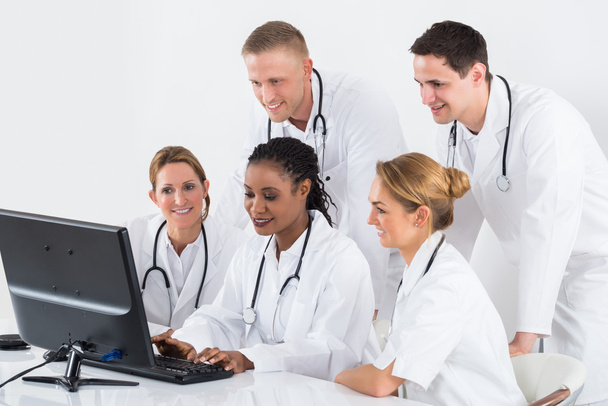 Group Of Doctors Looking At Computer  - 写真・画像