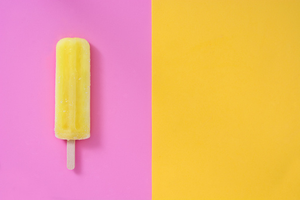 Lemon popsicle on pink and yellow background - Photo, Image