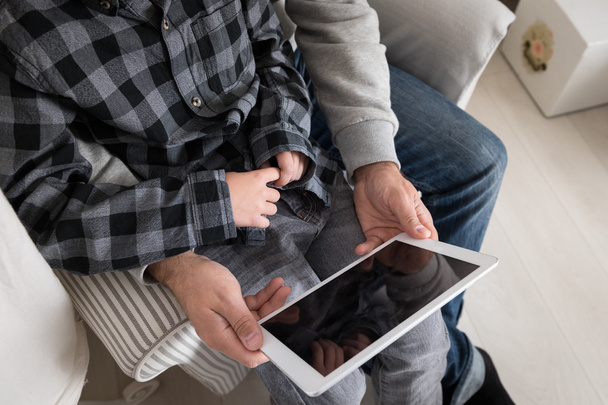 Vater und Sohn spielen mit digitalem Tablet - Foto, Bild