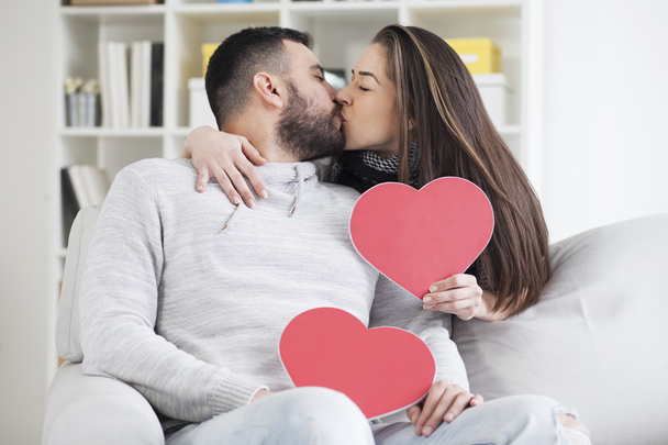 couple kissing behind paper hearts  - Fotografie, Obrázek