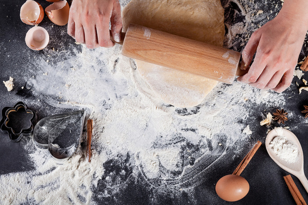 Ο φούρναρης φτιάχνει μπισκότα με ξύλινη κυλιόμενη καρφίτσα από την κορυφή - Φωτογραφία, εικόνα