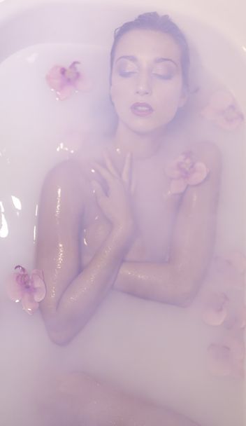 fiatal szőke modell gilr tejjel és virágokkal - Fotó, kép