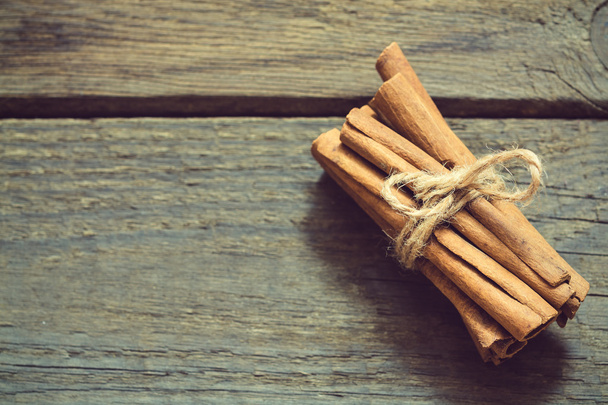 Bunch of cinnamon sticks on wooden background - Photo, image