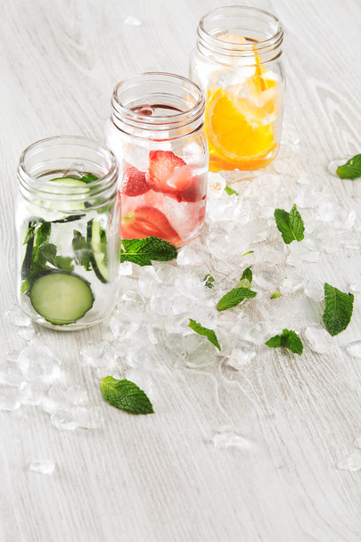 row rustic jars in crashed ice cubes with lemonade  - Foto, imagen