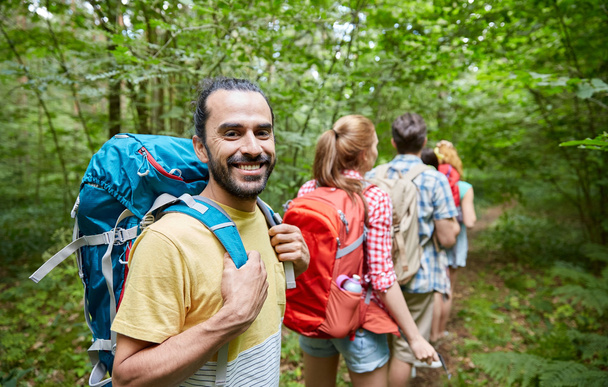 group of smiling friends with backpacks hiking - Foto, afbeelding