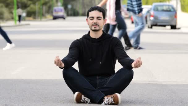 young man meditating in the middle of the street, for mindfulness concepts - Footage, Video
