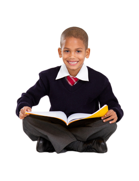 Primary schoolboy sitting on floor and reading - Фото, зображення