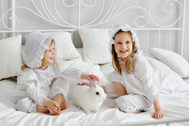 two little girls with a rabbit - Фото, изображение