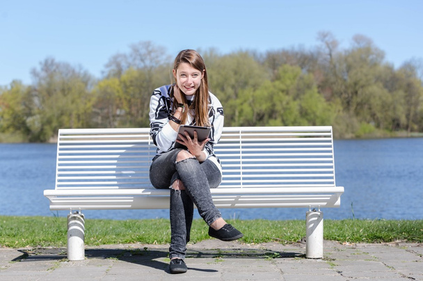 junge Frau mit Tablet in einem Park - Foto, Bild