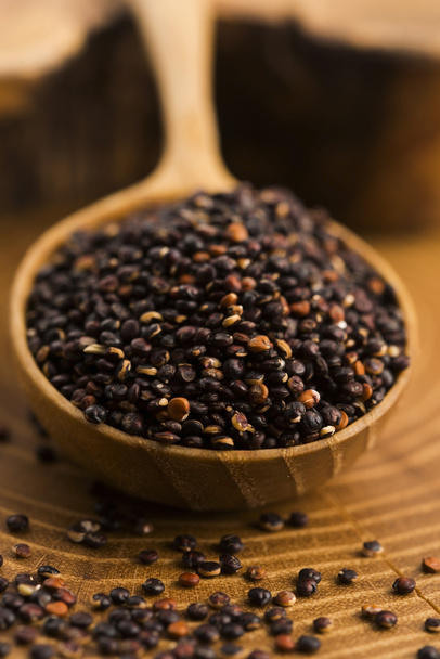 Black quinoa seeds on a wooden background - Φωτογραφία, εικόνα