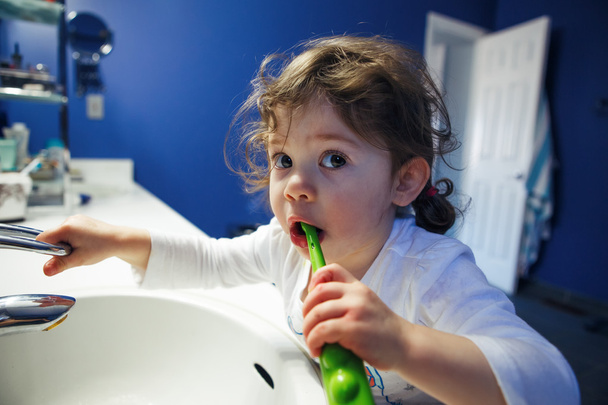 Banyo tuvalette çocuk yürümeye başlayan kız closeup portre yüz elleri diş başit su ile oynarken diş fırçalama, yaşam tarzı ev tarzı, günlük an, sabah rutin - Fotoğraf, Görsel