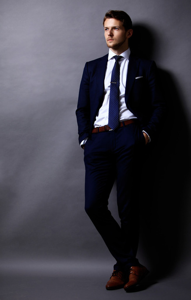 Cool businessman standing on grey - Fotografie, Obrázek