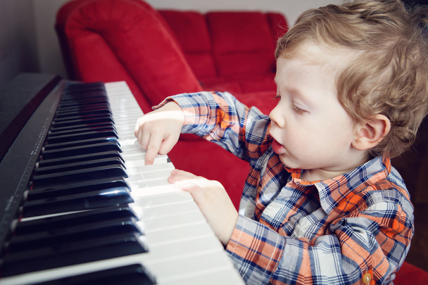 Primo piano ritratto di carino bianco caucasico bambino bambino bambino che suona inddors pianoforte con luce solare brillante sulla stanza, stile di vita quotidiano momento candido
 - Foto, immagini