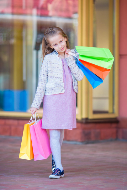 Porträt eines kleinen entzückenden Mädchens beim Einkaufen im Freien - Foto, Bild