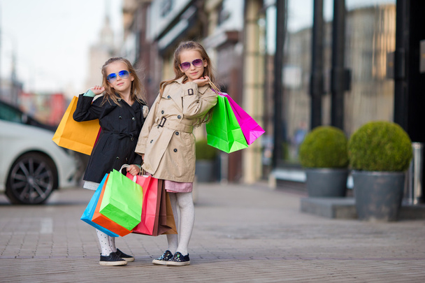 Urocze dziewczynki z torby na zakupy na zewnątrz - Zdjęcie, obraz