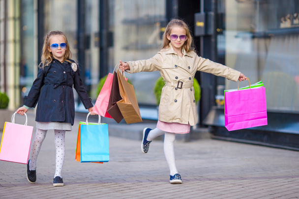 Meisje met boodschappentassen buitenshuis in grote stad in de mode - Foto, afbeelding
