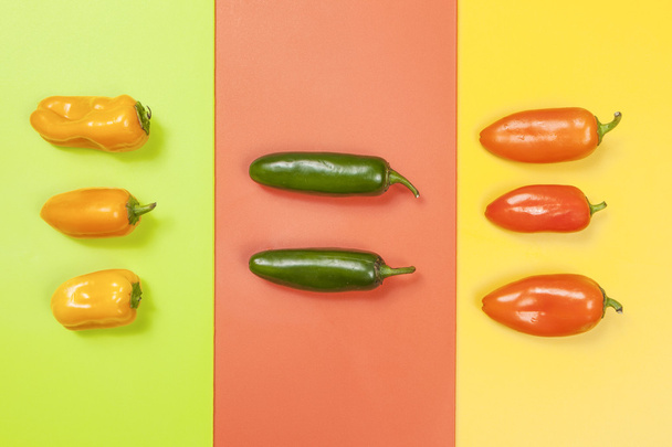 Peppers in color groups on vivid backgrounds. - Фото, зображення